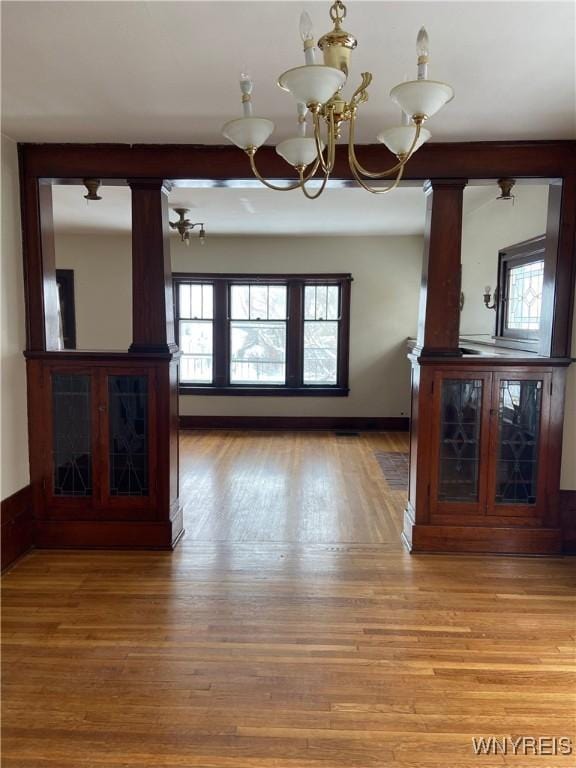 333 Colvin Ave, Buffalo, NY 14216 - unfurnished living room featuring a chandelier, light wood-style floors, and baseboards
