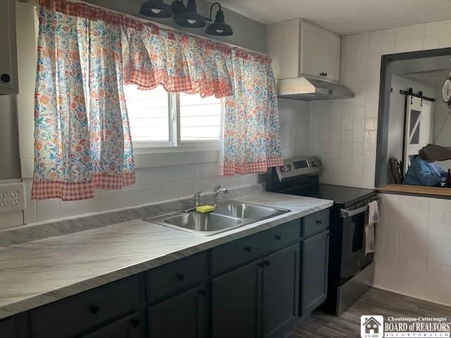 59 Pearl St, Hanover, NY 14062 - kitchen with electric range, under cabinet range hood, light countertops, a sink, and tile walls
