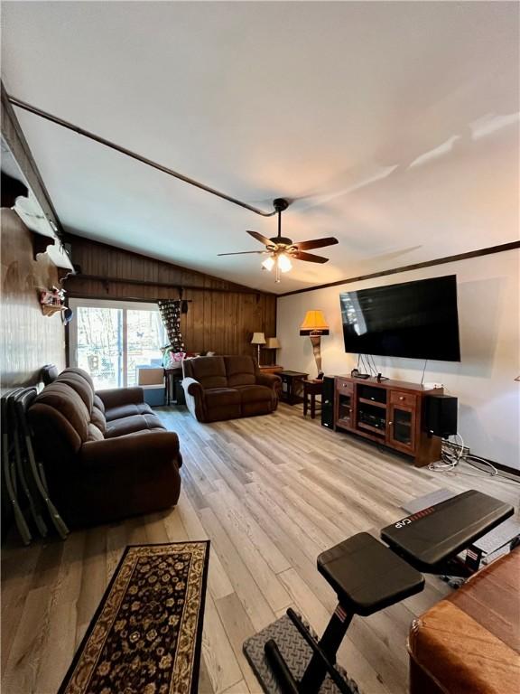 115 Forest Hills Dr, Elmira, NY 14905 - living room featuring lofted ceiling, wooden walls, a ceiling fan, and wood finished floors