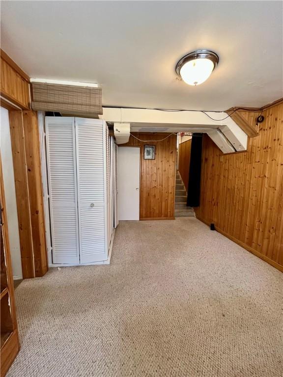 115 Forest Hills Dr, Elmira, NY 14905 - interior space with light carpet, wooden walls, and stairway