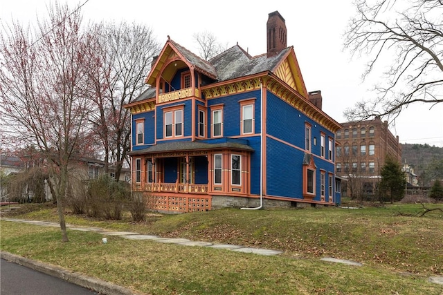 24 W 2nd St, Corning-City, NY 14830 - victorian house featuring a balcony, a chimney, a front lawn, and covered porch