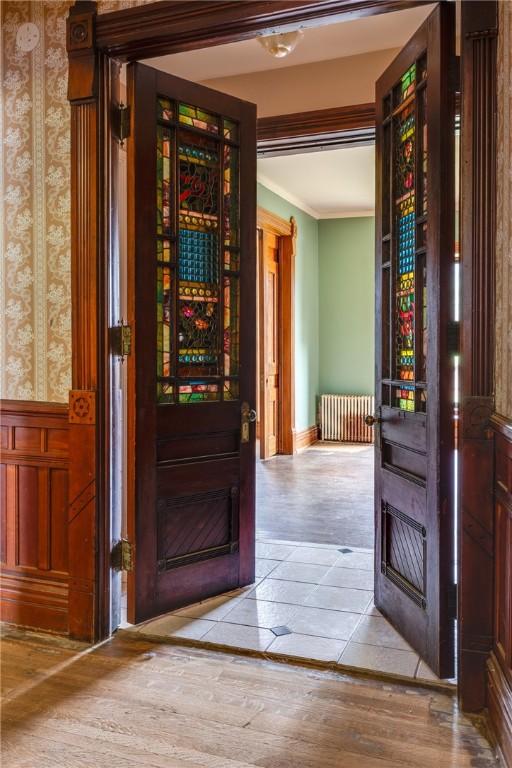 24 W 2nd St, Corning-City, NY 14830 - interior space featuring wallpapered walls, ornamental molding, radiator, and wood finished floors