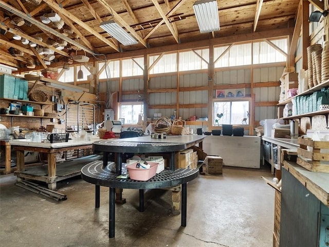 misc room with concrete flooring, metal wall, and a workshop area