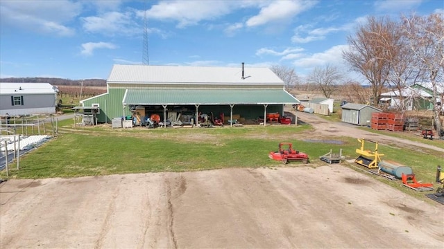 back of house featuring a yard, fence, an outdoor structure, and an outbuilding