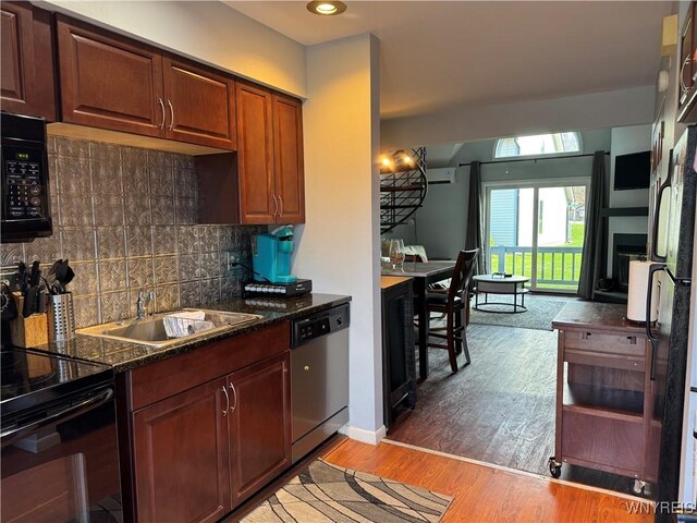 13 Wildflower, Ellicottville, NY 14731 - kitchen featuring baseboards, a sink, light wood-style floors, black appliances, and decorative backsplash