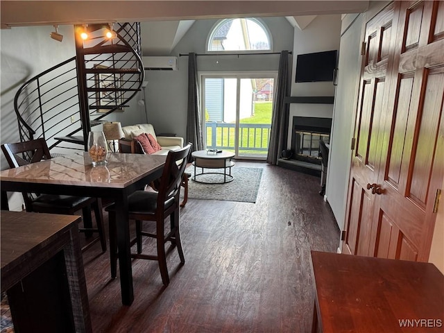 13 Wildflower, Ellicottville, NY 14731 - dining area featuring a glass covered fireplace, a wall mounted air conditioner, stairs, lofted ceiling, and wood finished floors