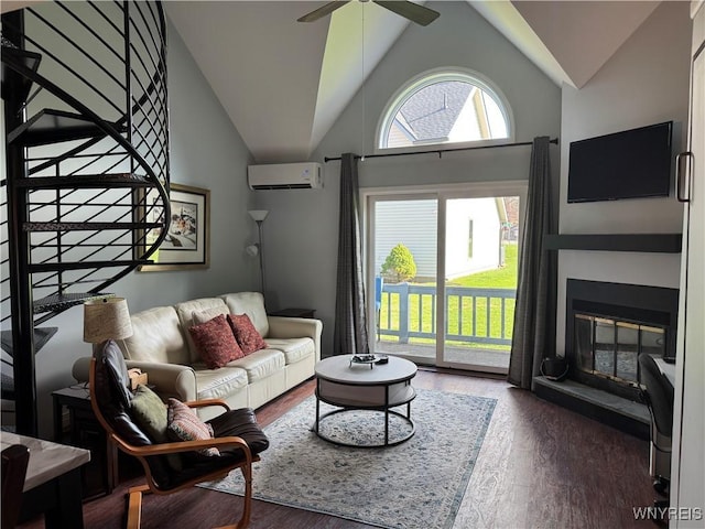 13 Wildflower, Ellicottville, NY 14731 - living room featuring a glass covered fireplace, a wall mounted air conditioner, stairway, ceiling fan, and wood finished floors