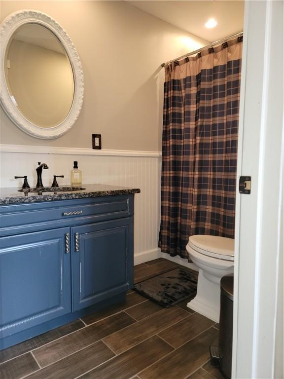 204 Ives Settlement Rd, Guilford, NY 13780 - full bath with a shower with shower curtain, toilet, wood tiled floor, vanity, and wainscoting