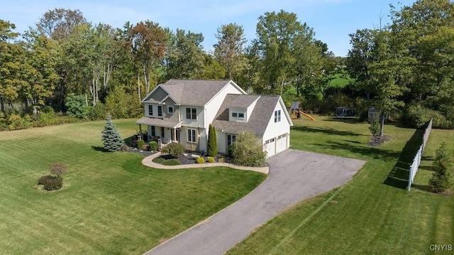 view of front of home with a front lawn, covered porch, a garage, and aphalt driveway