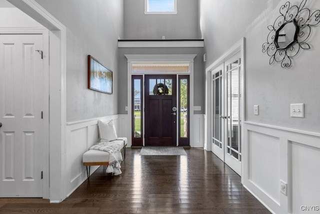foyer with dark wood-style flooring and wainscoting