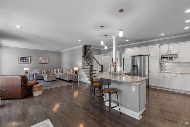 kitchen featuring a sink, open floor plan, and white cabinetry