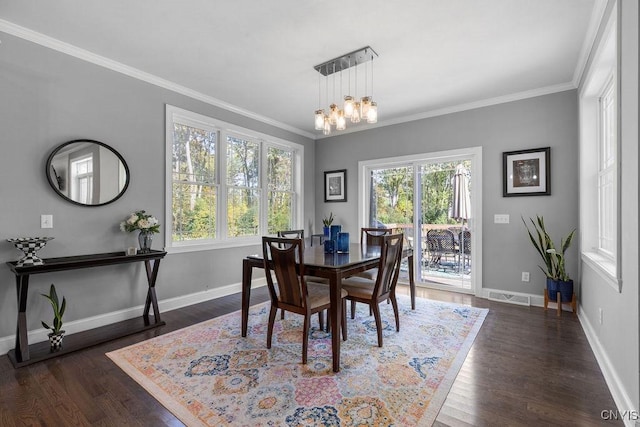 dining area featuring visible vents, an inviting chandelier, ornamental molding, and dark wood finished floors