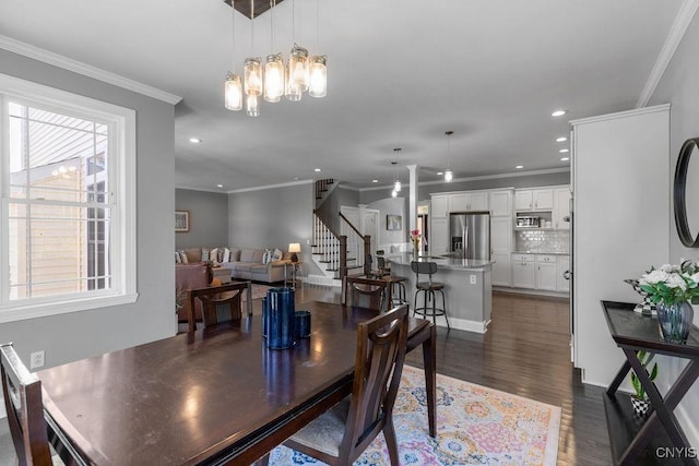 dining room with a notable chandelier, ornamental molding, dark wood finished floors, recessed lighting, and stairs