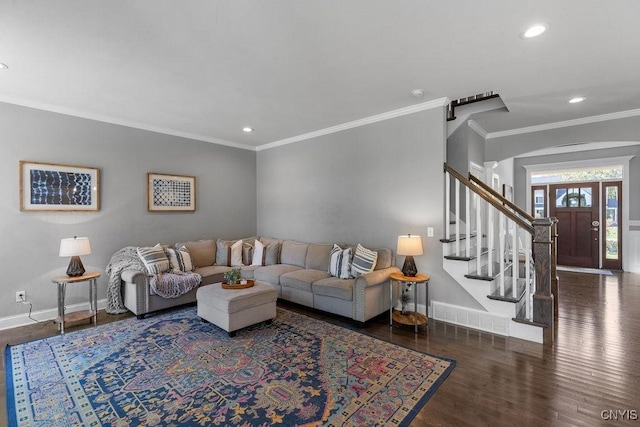 living room with visible vents, baseboards, arched walkways, wood finished floors, and stairs