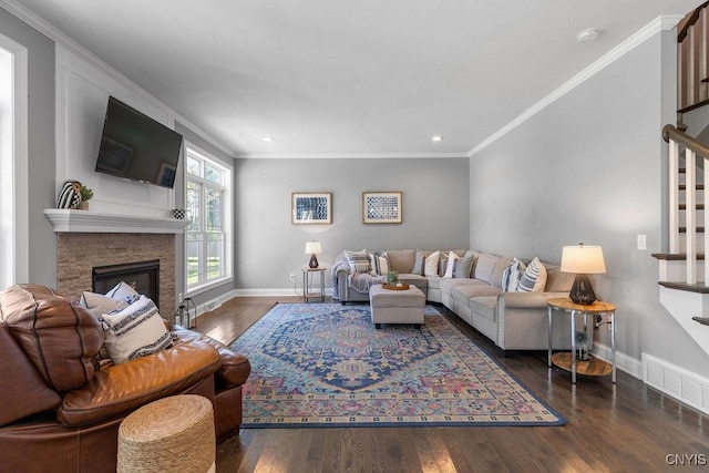 living area with ornamental molding, baseboards, wood finished floors, and stairs