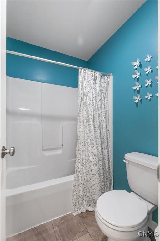 full bath with shower / bath combo with shower curtain and toilet