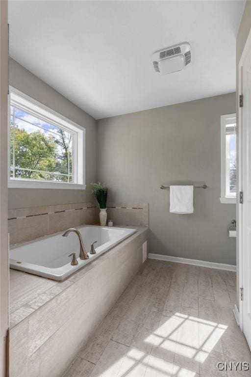 full bath featuring a bath and baseboards