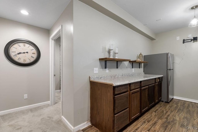 kitchen featuring baseboards, light countertops, freestanding refrigerator, open shelves, and wood finished floors