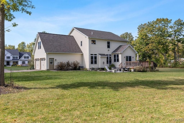 back of house with a yard, a deck, and a garage
