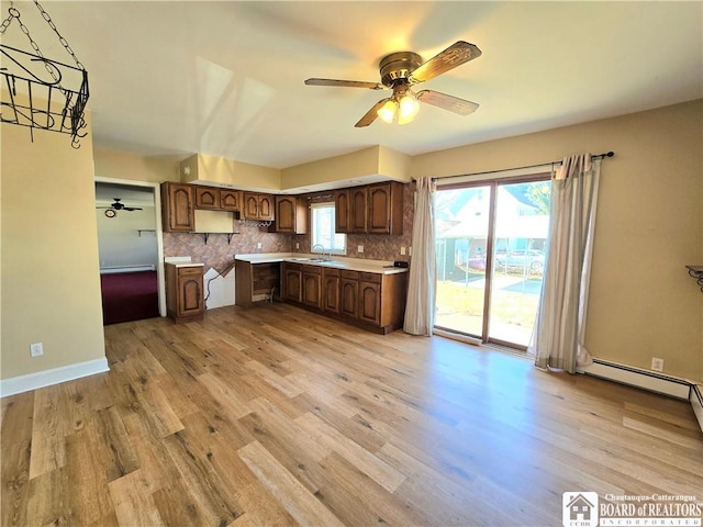 216 S Pleasant St, Shinglehouse, PA 16748 - kitchen featuring light wood-style floors, a ceiling fan, light countertops, a sink, and decorative backsplash