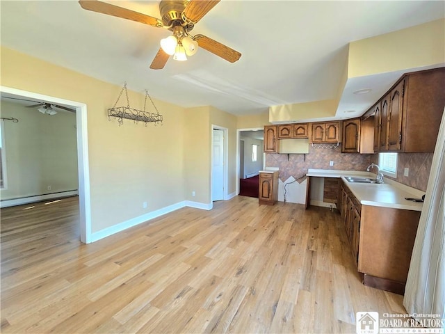 216 S Pleasant St, Shinglehouse, PA 16748 - kitchen with ceiling fan, light wood-type flooring, a sink, a baseboard radiator, and decorative backsplash