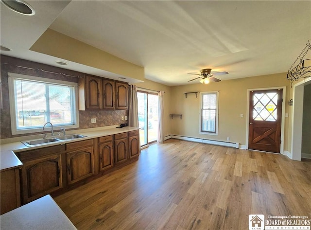 216 S Pleasant St, Shinglehouse, PA 16748 - kitchen with baseboard heating, light wood-style floors, a sink, and plenty of natural light