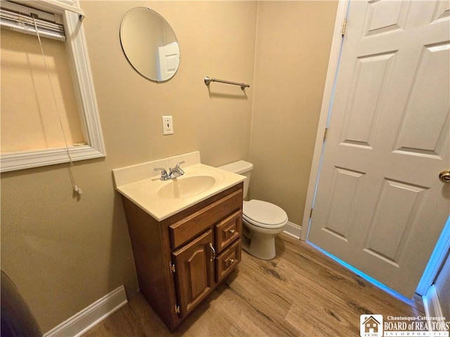 216 S Pleasant St, Shinglehouse, PA 16748 - half bath with vanity, baseboards, toilet, and wood finished floors
