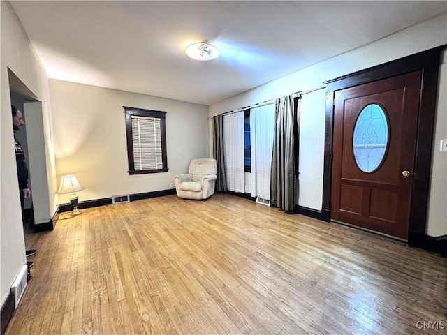 foyer featuring visible vents, baseboards, and light wood-type flooring
