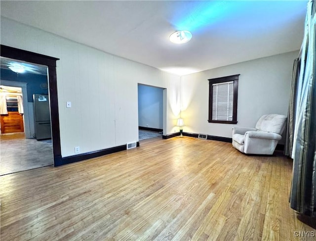 interior space with light wood-type flooring, baseboards, and visible vents