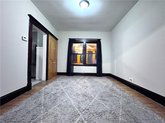 empty room with wood finished floors and baseboards