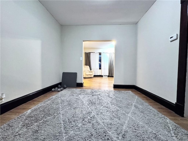 unfurnished room with baseboards and wood finished floors