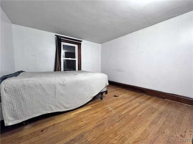 bedroom with hardwood / wood-style floors and baseboards