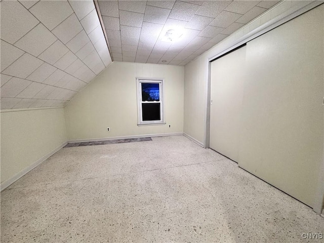bonus room featuring speckled floor and vaulted ceiling