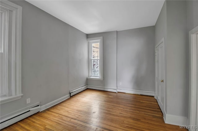 153 Allen St, Buffalo, NY 14201 - empty room featuring wood finished floors, a baseboard heating unit, and baseboards