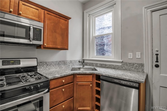 153 Allen St, Buffalo, NY 14201 - kitchen with brown cabinets, appliances with stainless steel finishes, a sink, and light stone counters