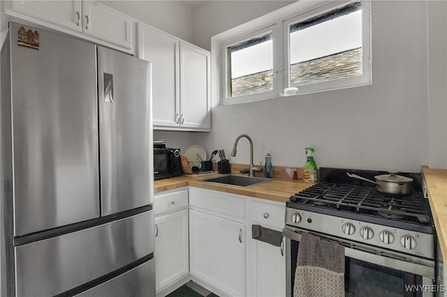 153 Allen St, Buffalo, NY 14201 - kitchen featuring a sink, wooden counters, white cabinetry, and stainless steel appliances