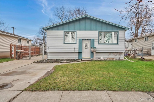 raised ranch featuring fence and a front lawn