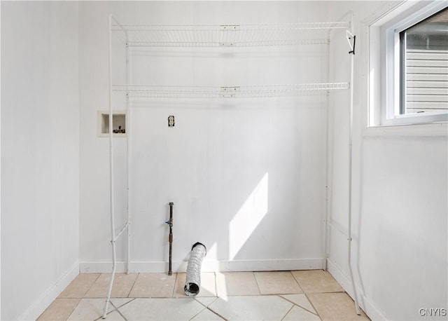 laundry area with baseboards, hookup for a washing machine, laundry area, and light tile patterned flooring