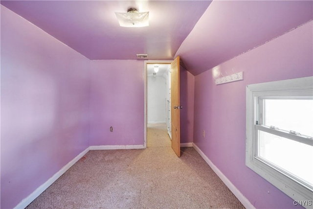 interior space with lofted ceiling, visible vents, baseboards, and carpet floors