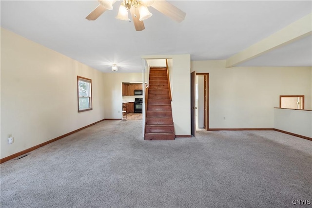 unfurnished living room featuring visible vents, baseboards, light colored carpet, and ceiling fan