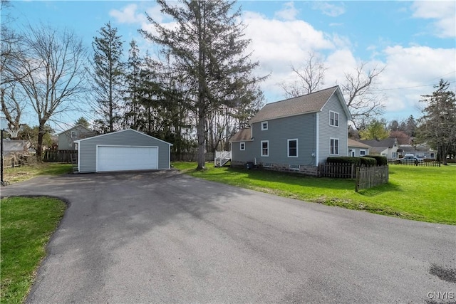 view of property exterior with a yard, fence, an outdoor structure, and a garage