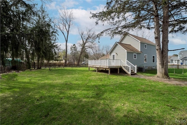 view of yard featuring a wooden deck, fence, and stairway