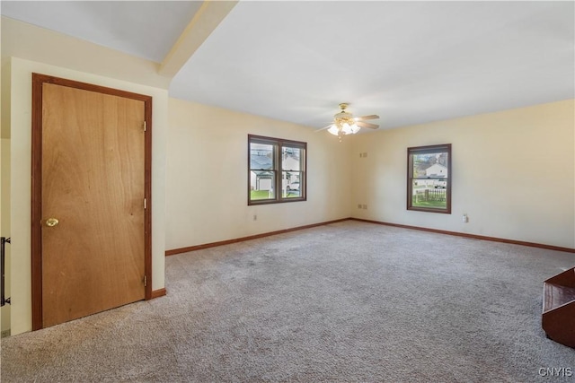 carpeted empty room featuring baseboards and ceiling fan