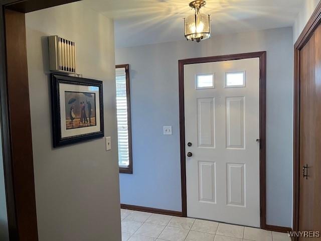 foyer entrance featuring a wealth of natural light, baseboards, and light tile patterned floors