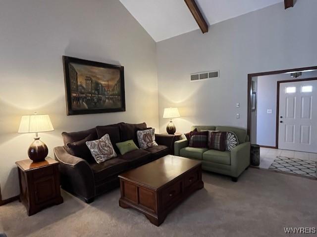 living area with beamed ceiling, light carpet, visible vents, and high vaulted ceiling