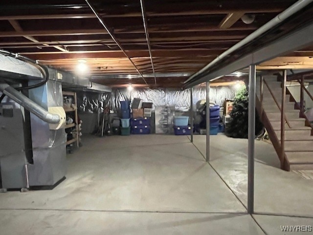 unfinished basement with stairway and heating unit