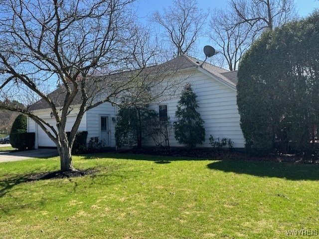 view of property exterior with a lawn, driveway, and a garage