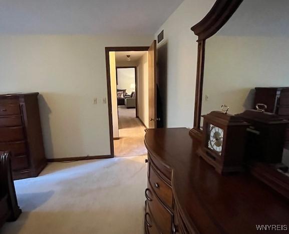 bedroom featuring baseboards, light carpet, and visible vents