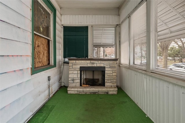 unfurnished sunroom featuring a fireplace