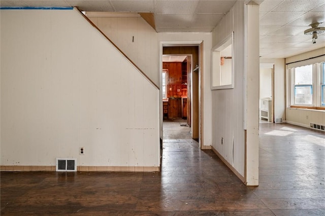 interior space featuring wooden walls, visible vents, and hardwood / wood-style flooring